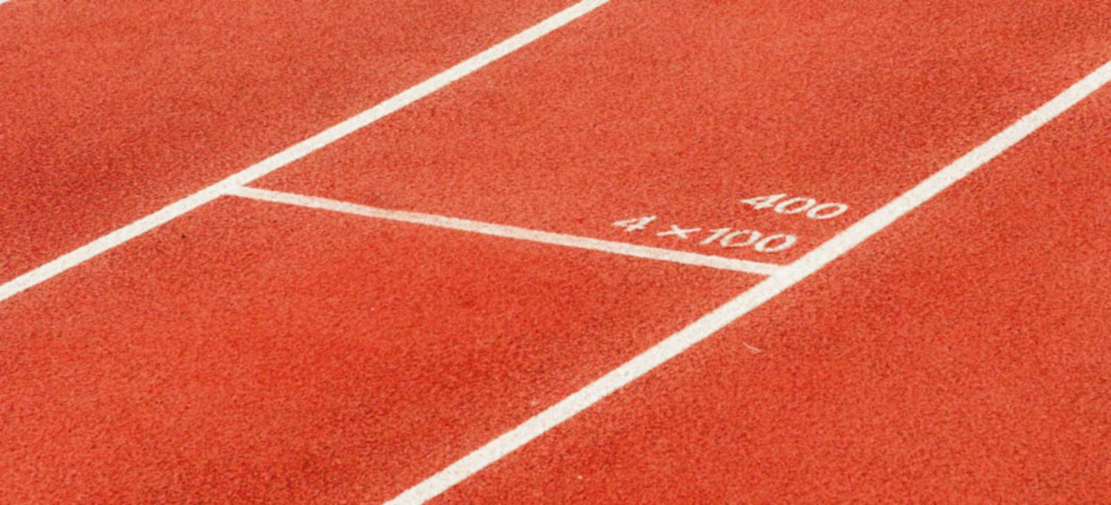 Calles de una pista de atletismo roja con las marcas 400 y 4×100