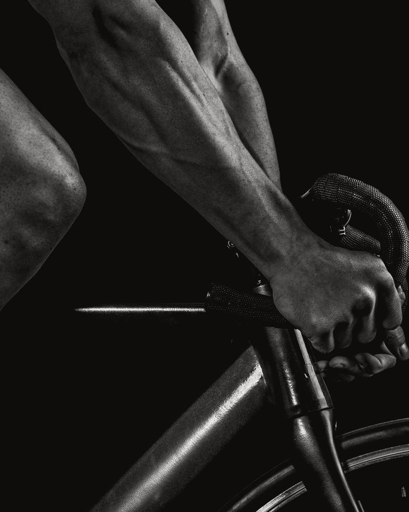 Antebrazo y mano de un ciclista sobre el manillar, en blanco y negro